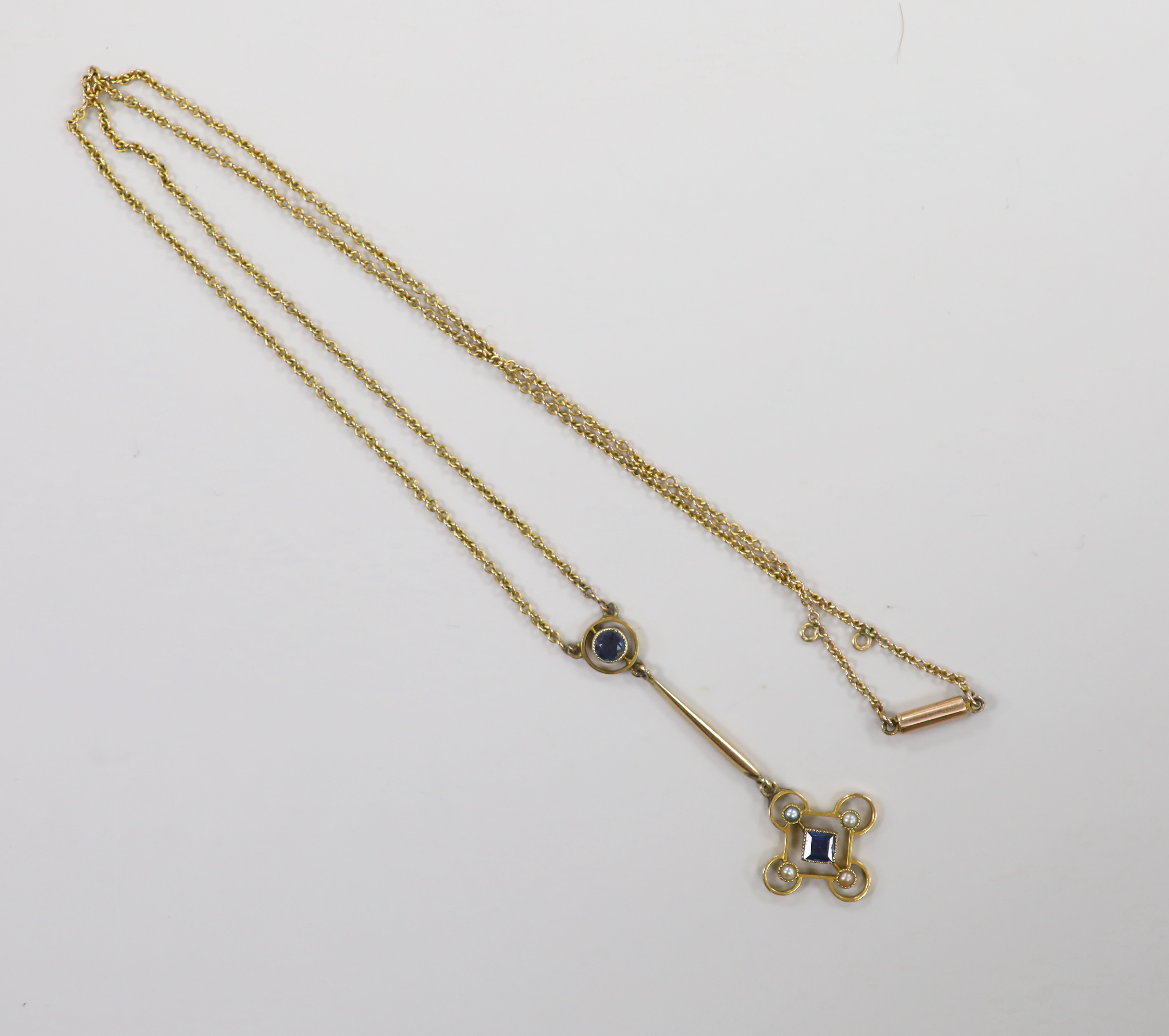 An Edwardian yellow metal, sapphire? and seed pearl set drop pendant necklace, pendant 43mm, chain 43cm, gross weight 3.4 grams.